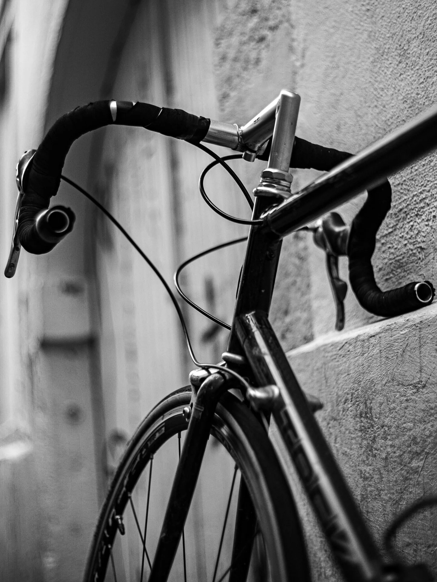 Close-up black-and-white shot of a bicycle handlebar wrapped in tape, highlighting texture and contrast. | Leica Sl | N/A | f2.0 | 1/1000s | ISO 100