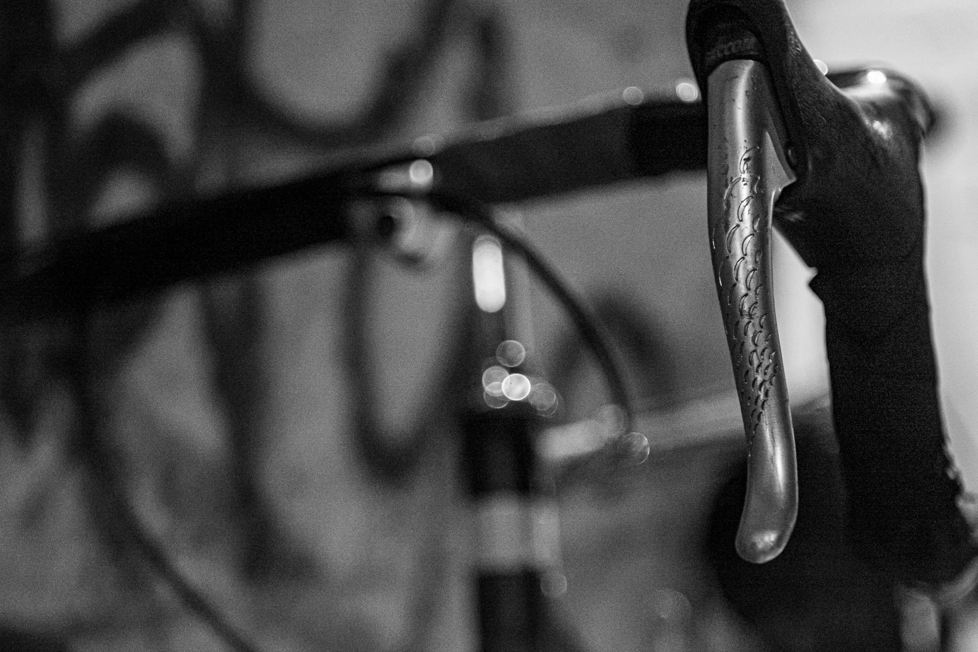 Black-and-white photograph of a bicycle handlebar in a horizontal composition, focusing on metal curves and grip. | Leica SL | N/A | f4.0 | 1/80s | ISO 100