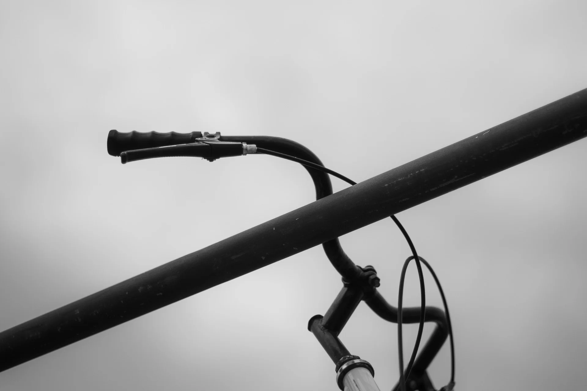 Black-and-white image of a child's bicycle with helmet and basket abandoned on a sidewalk path in Italy. | Leica SL | N/A | f2.8 | 1/160s | ISO 100